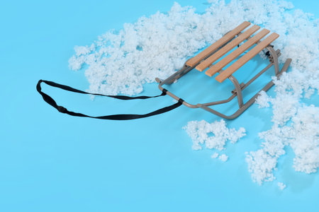 Empty sled with snow on blue backgroundの写真素材