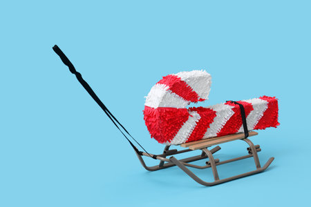 Sled with candy cane pinata on blue backgroundの写真素材