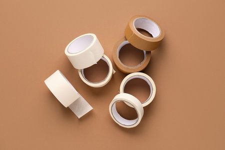 Many rolls of different masking tape on brown background