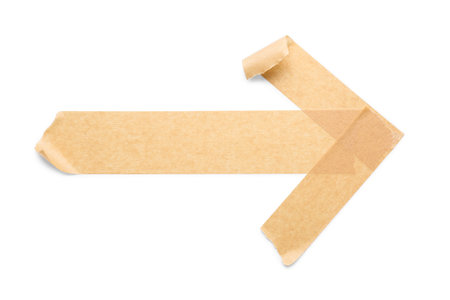 Arrow made of brown masking tape strips on white backgroundの写真素材