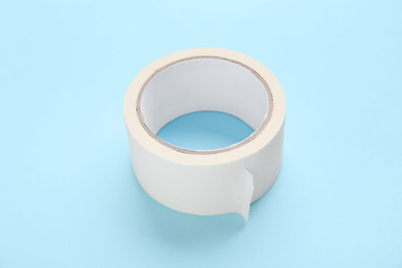 Roll of white masking tape on blue background