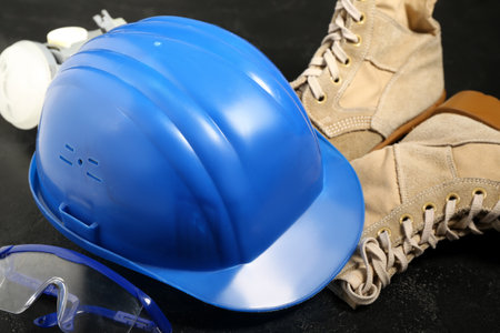 Hardhat with boots and safety equipment on black grunge background, closeupの写真素材