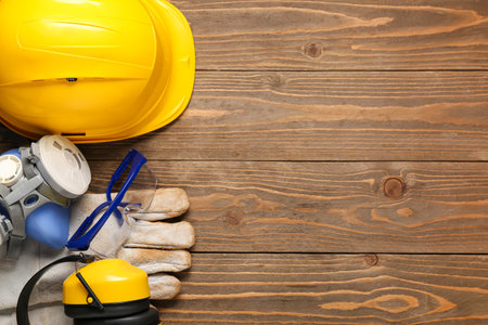 Hardhat with gloves, respirator and safety glasses on wooden backgroundの写真素材