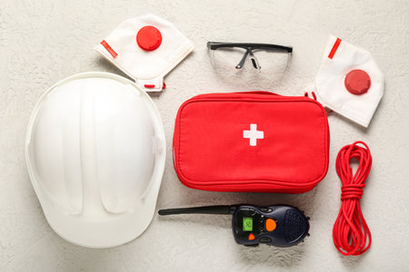 Hardhat, radio transceiver, first aid kit and safety equipment on white grunge backgroundの写真素材