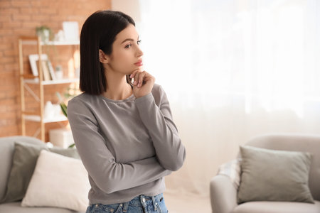 Thoughtful young woman at homeの写真素材