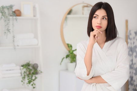 Thoughtful young woman in bathroomの写真素材