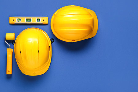 Hardhats and construction tools on blue background, top viewの写真素材