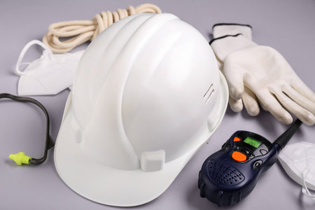 Hardhat, radio transceiver and safety equipment on gray backgroundの写真素材