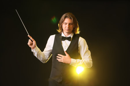 Young male conductor on dark backgroundの写真素材