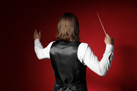 Male conductor on red background, back viewの写真素材