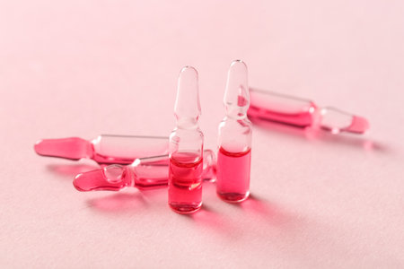 Glass ampoules on pink backgroundの写真素材