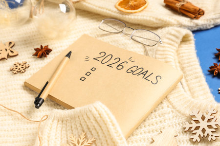 Notebook with empty to do list for 2026 year and sweater on blue background