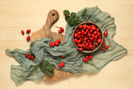 Bowl and cutting board with fresh rose hip berries on wooden backgroundの写真素材