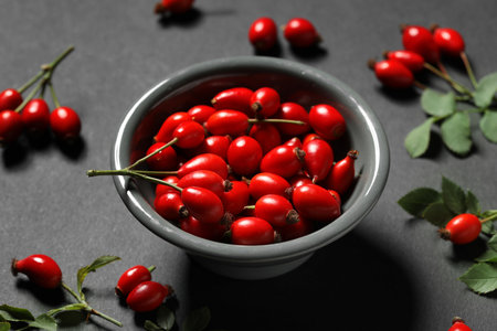 Bowl with fresh rose hip berries on black background, closeupの写真素材
