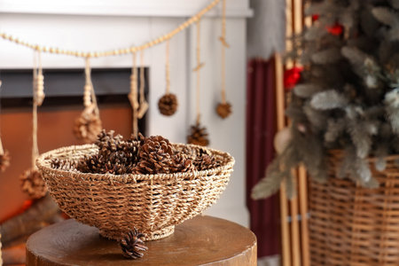 Wicker basket with coniferous cones on table in living roomの写真素材