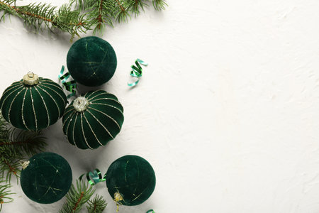 Christmas balls with fir tree branches and serpentine on light backgroundの写真素材