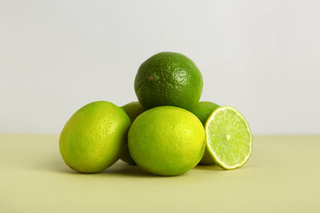 Fresh ripe limes on green table against gray backgroundの写真素材