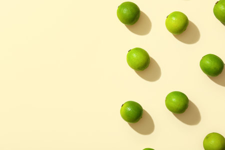 Many fresh ripe limes on yellow backgroundの写真素材