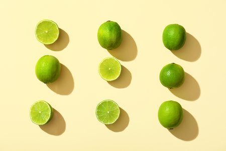 Fresh ripe limes on yellow backgroundの写真素材