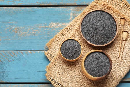 Bowls with poppy seeds on blue wooden backgroundの写真素材