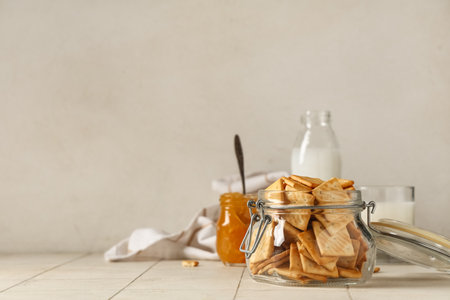 Composition with glass jar of crackers on beige tile tableの写真素材