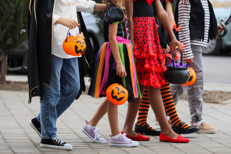 Group of kids dressed for Halloween with candies walking on streetの写真素材