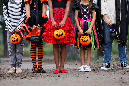 Group of kids dressed for Halloween with candies in parkの写真素材