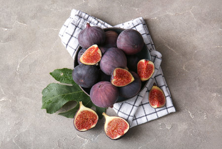 Bowl with fresh ripe figs on gray backgroundの写真素材