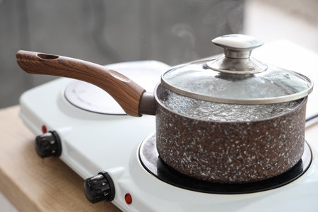 Saucepan with boiling water on stove in kitchen, closeupの写真素材