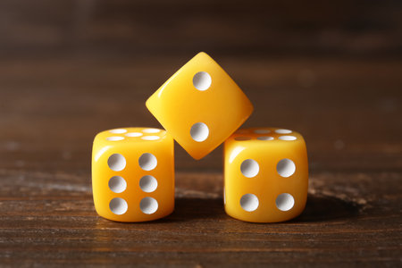 Yellow game dices on wooden backgroundの写真素材