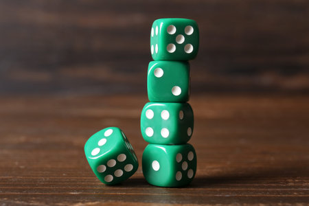 Green game dices on wooden background