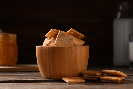 Composition with bowl of tasty crackers on brown wooden table, closeupの写真素材