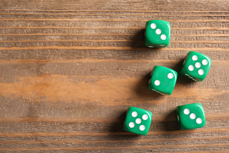 Green dices on wooden backgroundの写真素材
