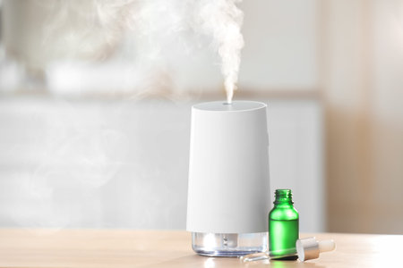 Air humidifier with essential oil on table in bathroom, closeup