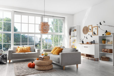 Interior of light living room decorated for Halloween with sofas and shelf unitsの写真素材