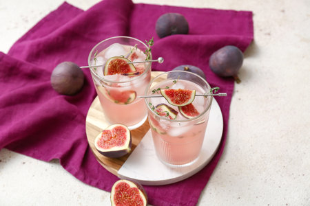 Composition with glasses of fresh fig lemonade on white grunge background, closeupの写真素材