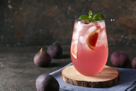 Glass of tasty fig lemonade on brown grunge background, closeupの写真素材