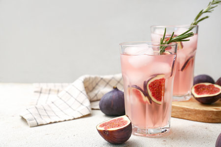Glasses of fresh fig lemonade on white grunge table, closeupの写真素材