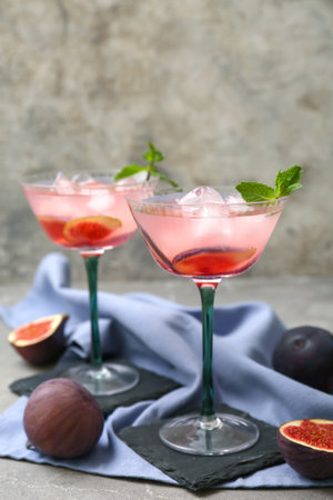 Glasses of tasty fig lemonade on gray grunge table, closeupの写真素材
