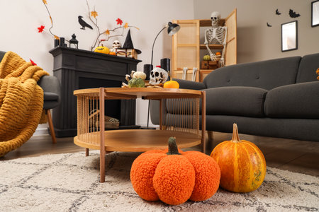 Table with skull and pumpkins in living room decorated for Halloweenの写真素材