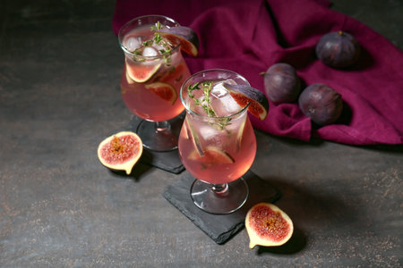 Glasses of tasty fig lemonade on black grunge background, closeupの写真素材