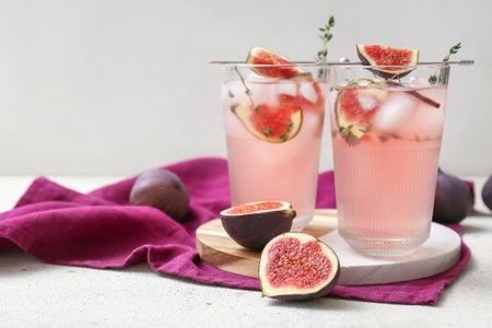 Composition with glasses of fresh fig lemonade on white grunge table, closeupの写真素材