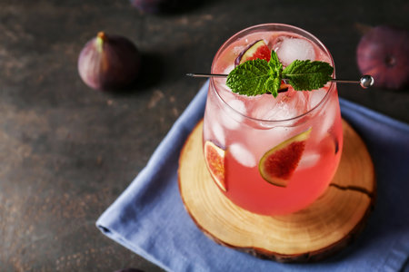 Glass of tasty fig lemonade on brown grunge background, closeupの写真素材
