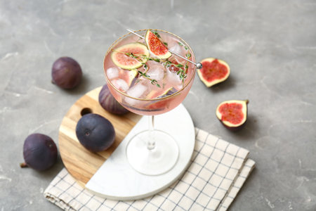 Glass of tasty fig lemonade on gray grunge background, closeupの写真素材