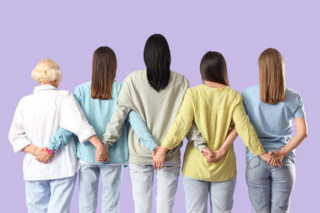 Group of beautiful women hugging on lilac background, back view. Feminism conceptの写真素材