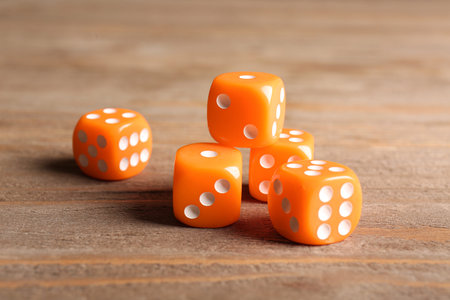Orange dices on wooden background
