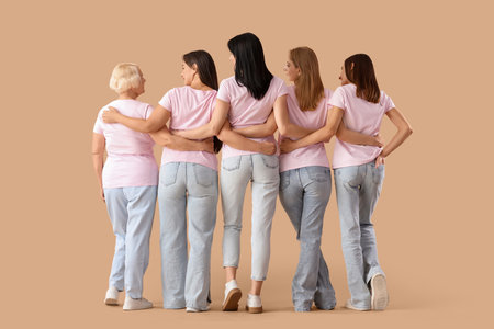 Group of beautiful women hugging on beige background, back view. Feminism conceptの写真素材
