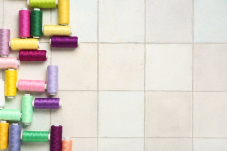 Colorful thread spools on white tile backgroundの写真素材