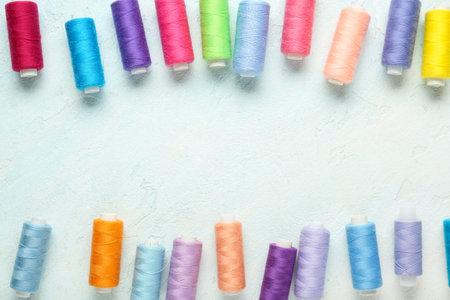 Frame made of colorful thread pools on light blue backgroundの写真素材