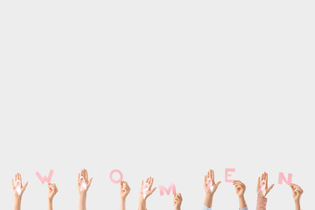 Many female hands with pink awareness ribbons and the word WOMEN on white background. Breast cancer conceptの写真素材